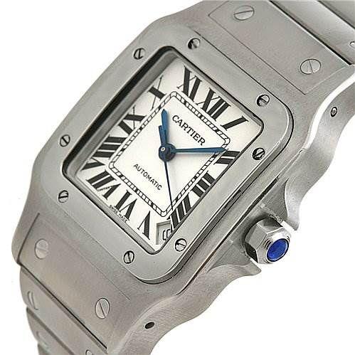 The image shows a Cartier Santos W20098D6 Stainless Steel Silver Dial W20098D6 Stainless Steel Silver Dial model watch from a front angle, highlighting its square dial, blue hands, Roman numerals, and metal bracelet.
