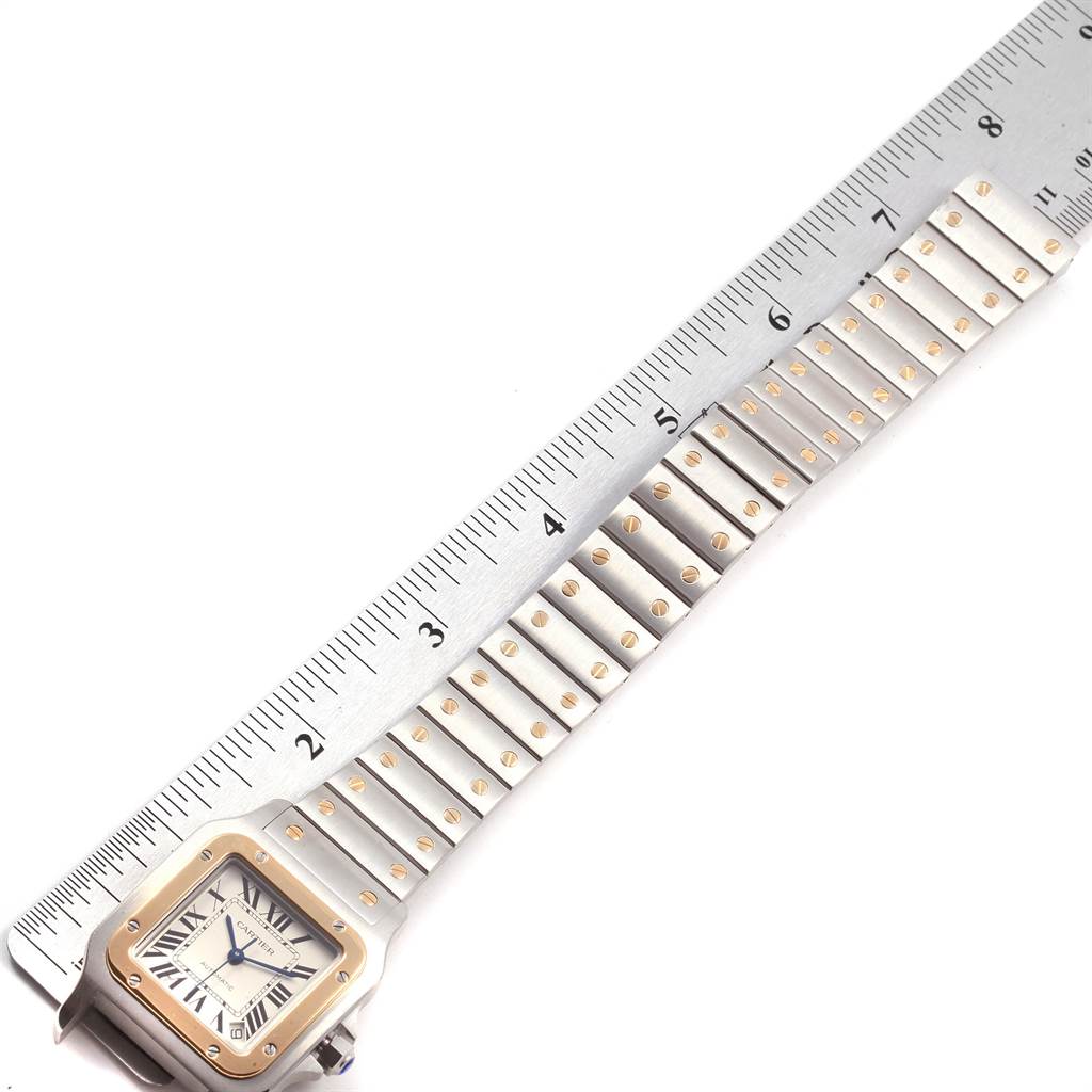 The image shows a top view of a Cartier Santos W20099C4 Stainless Steel Silver Dial W20099C4 Stainless Steel Silver Dial watch, featuring the bezel, dial, and part of the bracelet alongside a ruler.