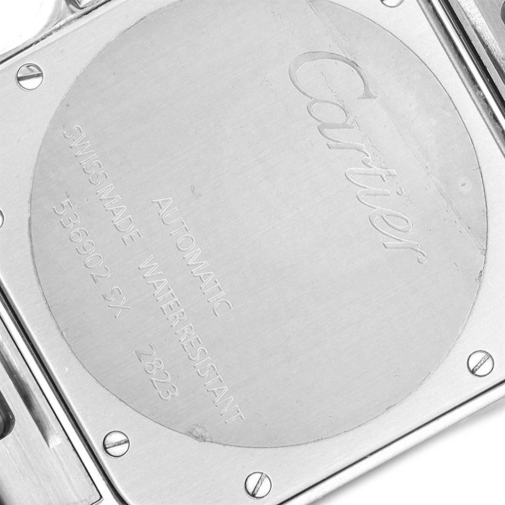 This is a close-up view of the back case of a Cartier Santos W20099C4 Men's Stainless Steel Silver Dial W20099C4 Men's Stainless Steel Silver Dial watch, displaying engraving details and screws.