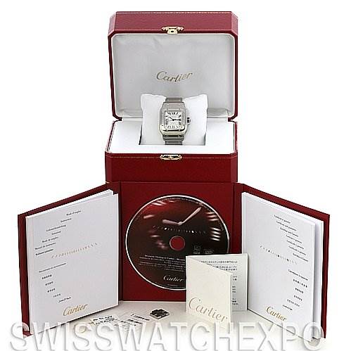 The image shows a Cartier Santos W20098D6 Stainless Steel Silver Dial W20098D6 Stainless Steel Silver Dial watch in its open box along with its accessories, including manuals and a CD, all presented from a front angle.