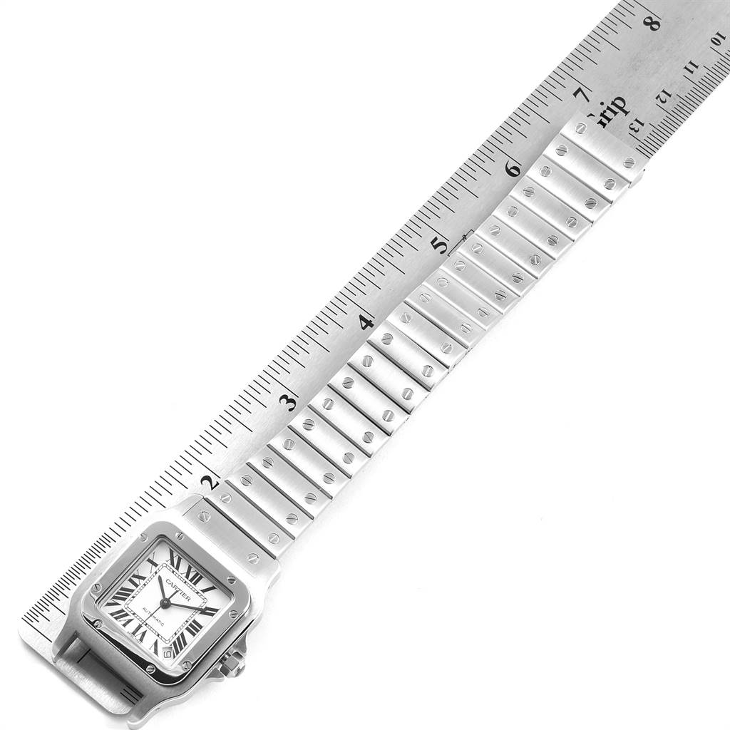 The image shows a Santos model by Cartier, with the watch face and bracelet aligned next to a ruler for measurement.