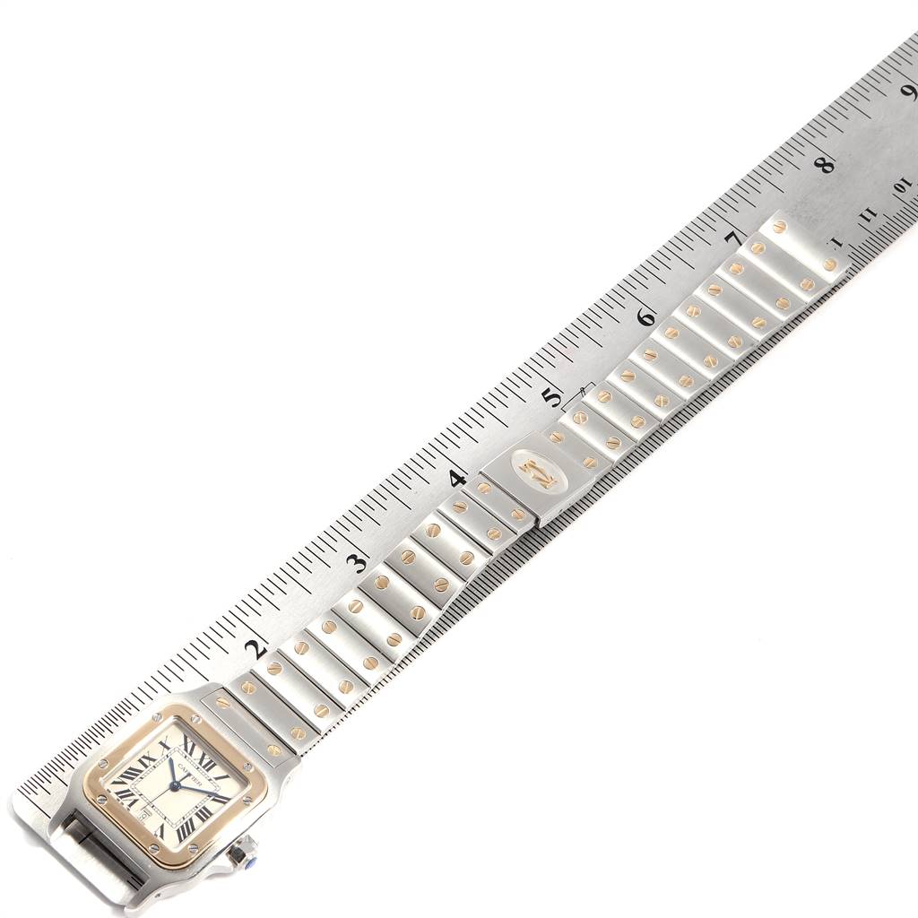 This image shows a Santos model watch by Cartier, highlighting the face and full metal bracelet, placed next to a ruler for scale.