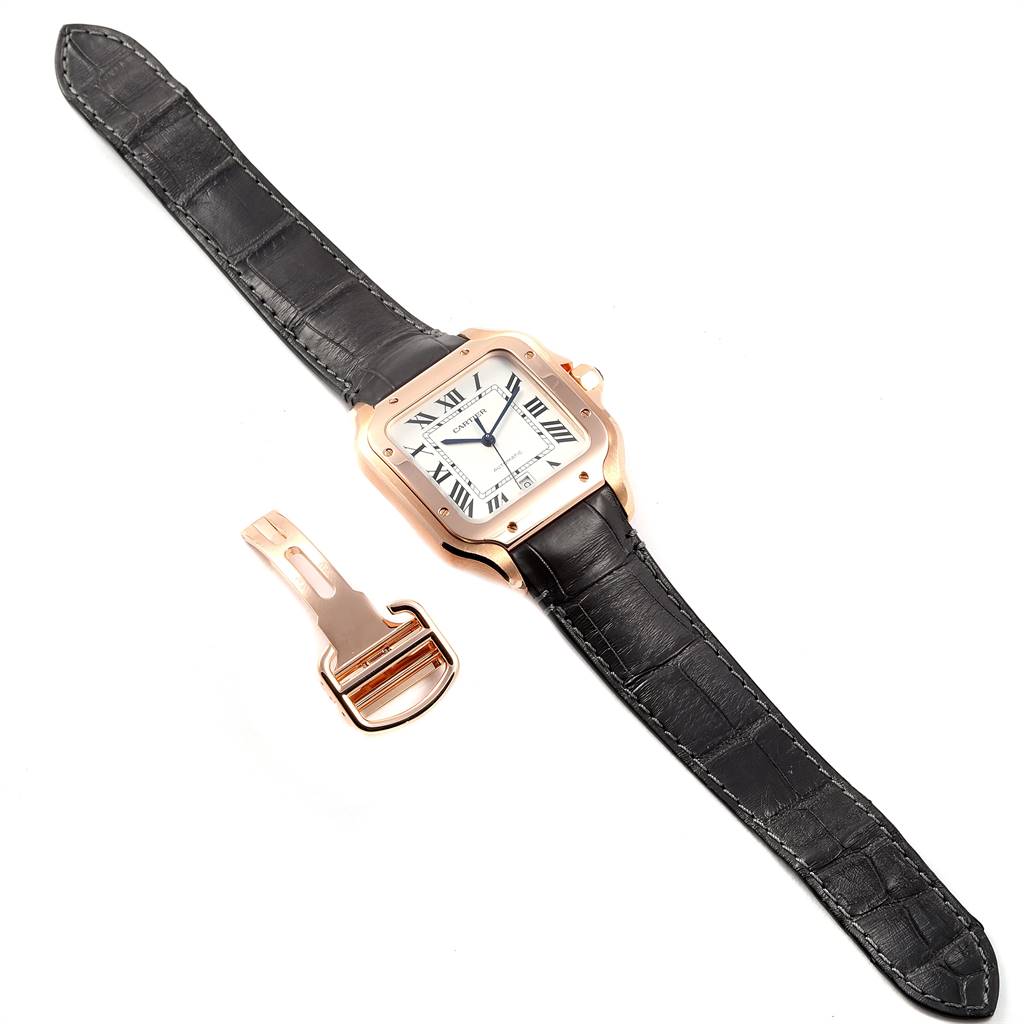 Top view of a Cartier Santos WGSA0007 Men's Rose Gold Silver Dial WGSA0007 Men's Rose Gold Silver Dial watch with a black leather strap and a detached gold clasp accessory.
