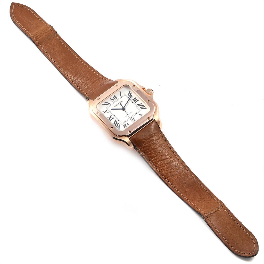 The Cartier Santos WGSA0007 Men's Rose Gold Silver Dial WGSA0007 Men's Rose Gold Silver Dial watch is shown from a top-down angle, displaying its square dial, leather strap, and Roman numeral indices.