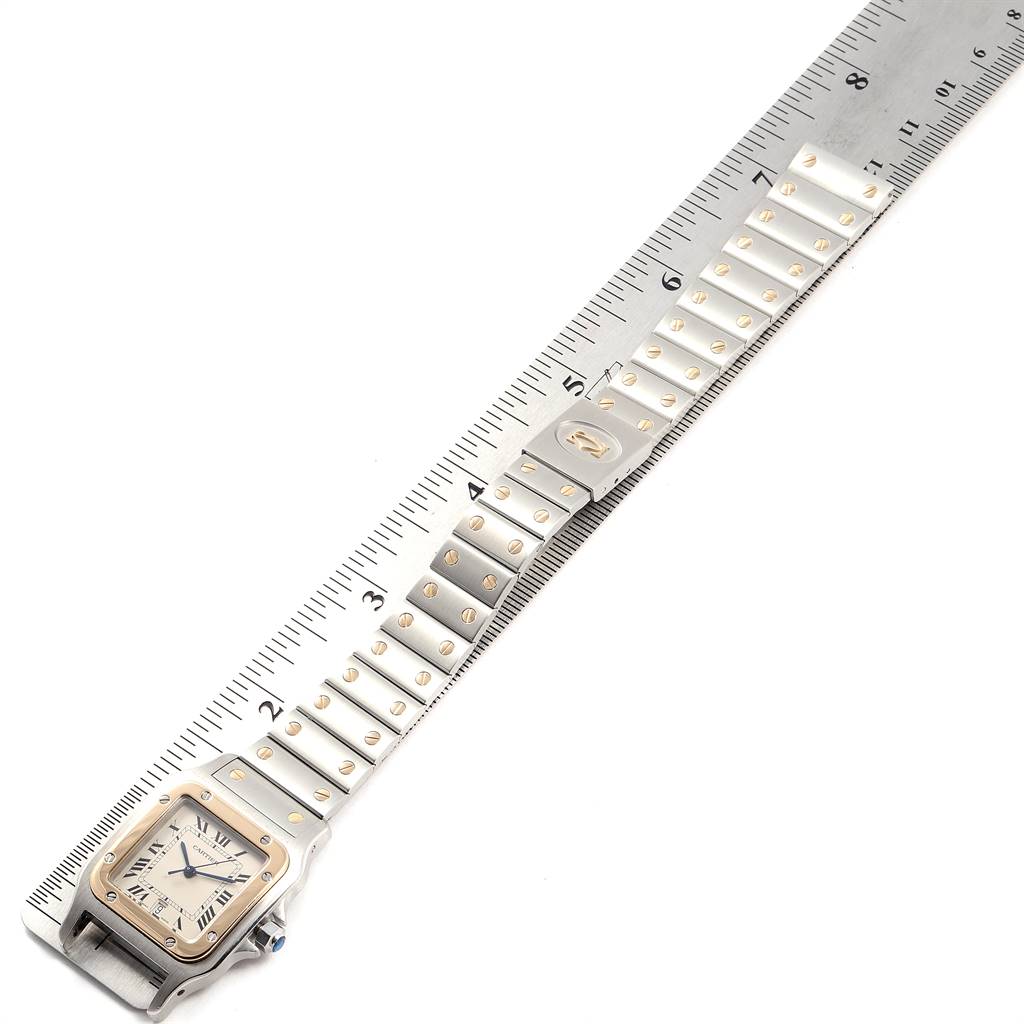 The image shows a Cartier Santos 187901 Stainless Steel Silver Dial 187901 Stainless Steel Silver Dial watch laid flat on a ruler, displaying its face, bracelet, and clasp.