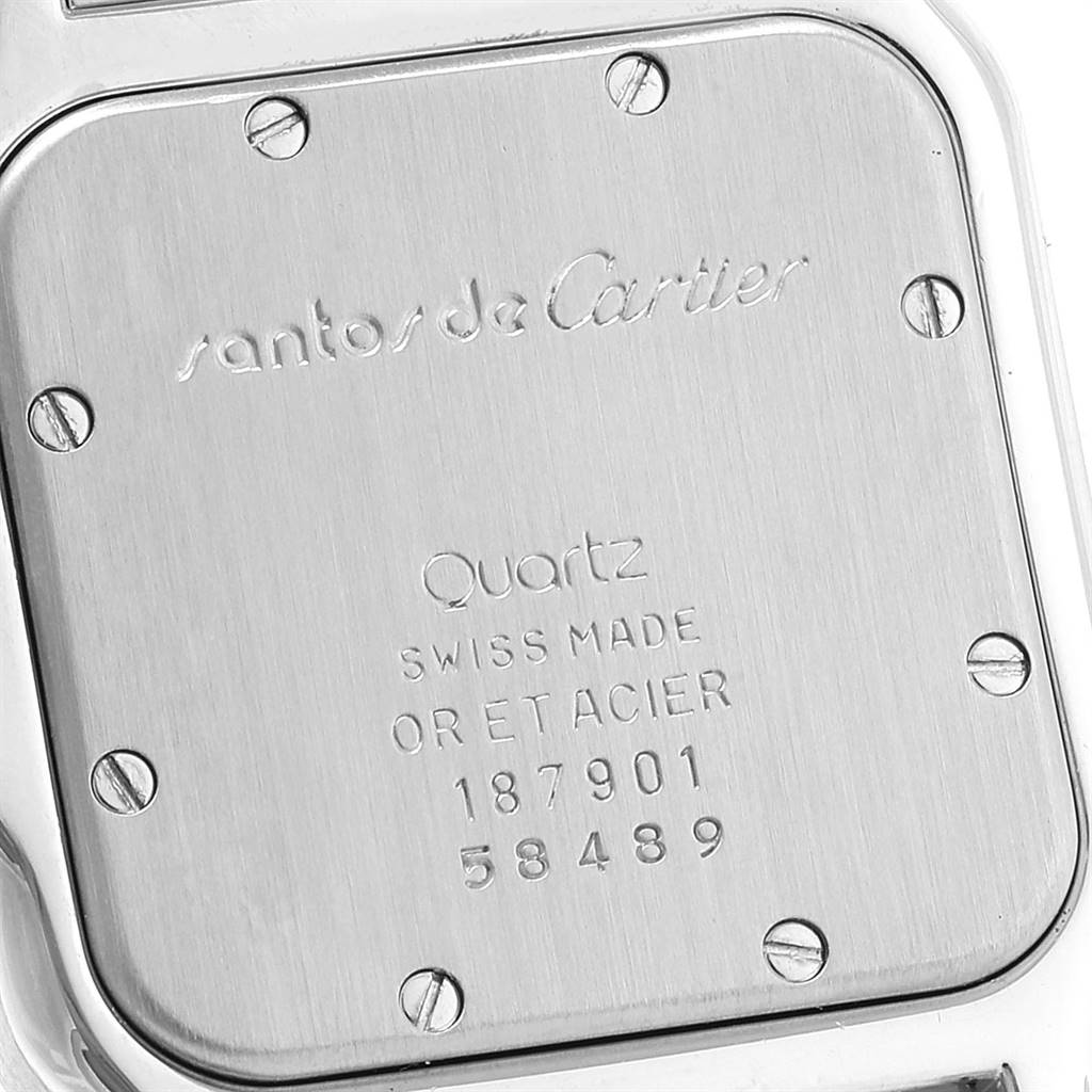 The image shows the back case of a Santos model watch by Cartier, highlighting its screws and engravings.