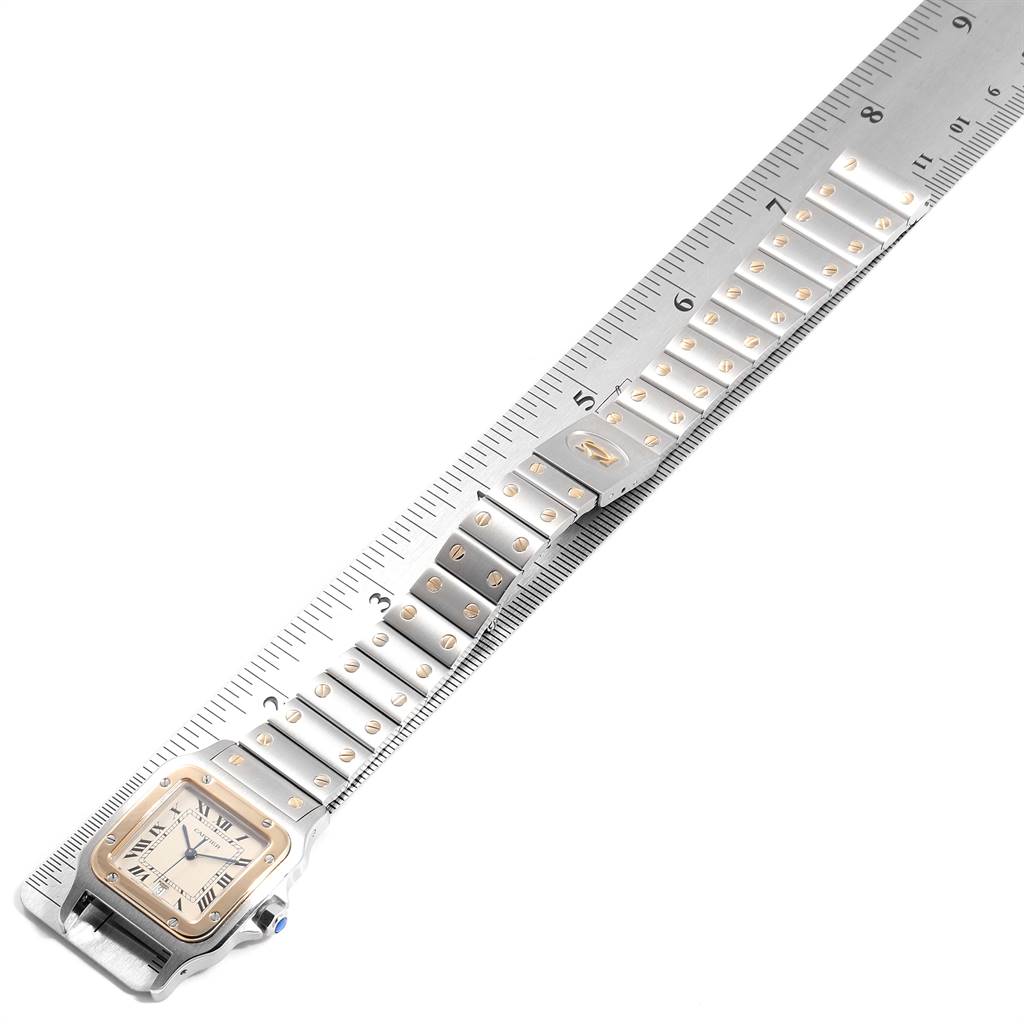 The image shows the Santos model by Cartier from an angled view, highlighting the bracelet and watch face next to a ruler.