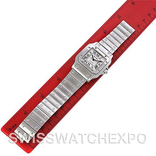 The Cartier Santos W20055D6 Men
s Stainless Steel Silver Dial W20055D6 Men
s Stainless Steel Silver Dial watch is shown from a top view, with the entire watch laid flat alongside a red ruler.