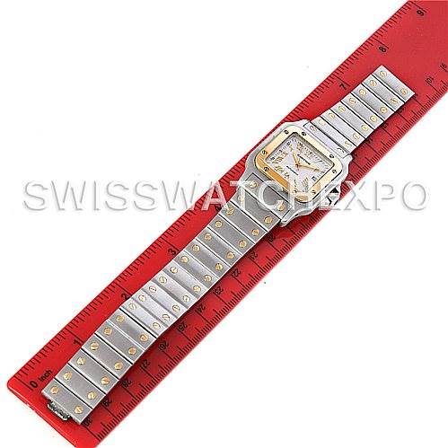This Cartier Santos W20058C4 Men's Stainless Steel Silver Dial W20058C4 Men's Stainless Steel Silver Dial watch is shown laid flat with its band fully extended alongside a red ruler for scale.