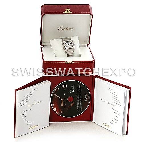 The image shows the Cartier Santos W20098D6 Men's Stainless Steel Silver Dial W20098D6 Men's Stainless Steel Silver Dial watch angled inside its box, with accompanying manuals and a CD displayed around it.