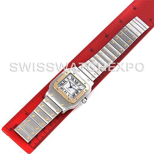 The image shows a top-down view of a Cartier Santos W20099C4 Men's Stainless Steel Silver Dial W20099C4 Men's Stainless Steel Silver Dial watch, laid next to a red ruler with its bracelet fully extended.