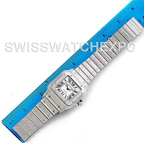 This image shows the top view of a Cartier Santos W20098D6 Men
s Stainless Steel Silver Dial W20098D6 Men
s Stainless Steel Silver Dial watch placed next to a blue ruler.