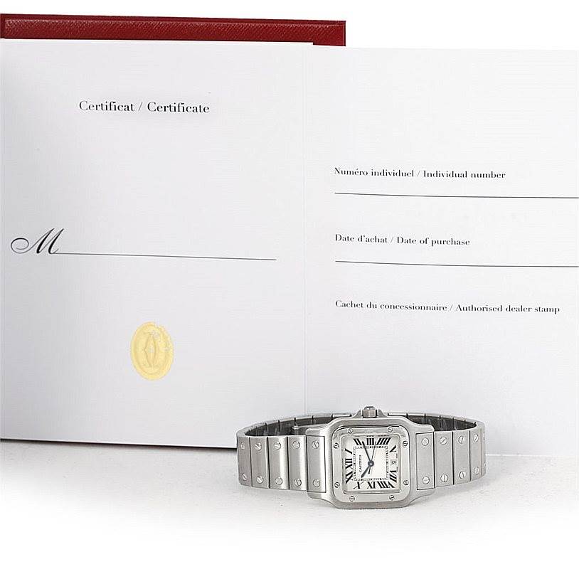 The image shows a Cartier Santos W20060D6 Men
s Stainless Steel Silver Dial W20060D6 Men
s Stainless Steel Silver Dial watch lying flat beneath an open certificate of Best Quality
ity booklet.