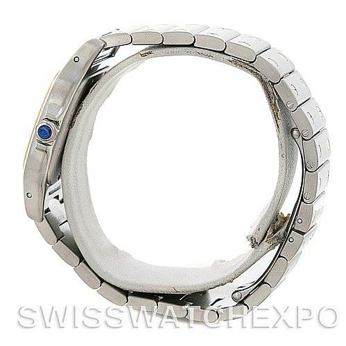 The image shows a side view of the Santos model by Cartier, highlighting its silver bracelet and a blue cabochon on the crown.