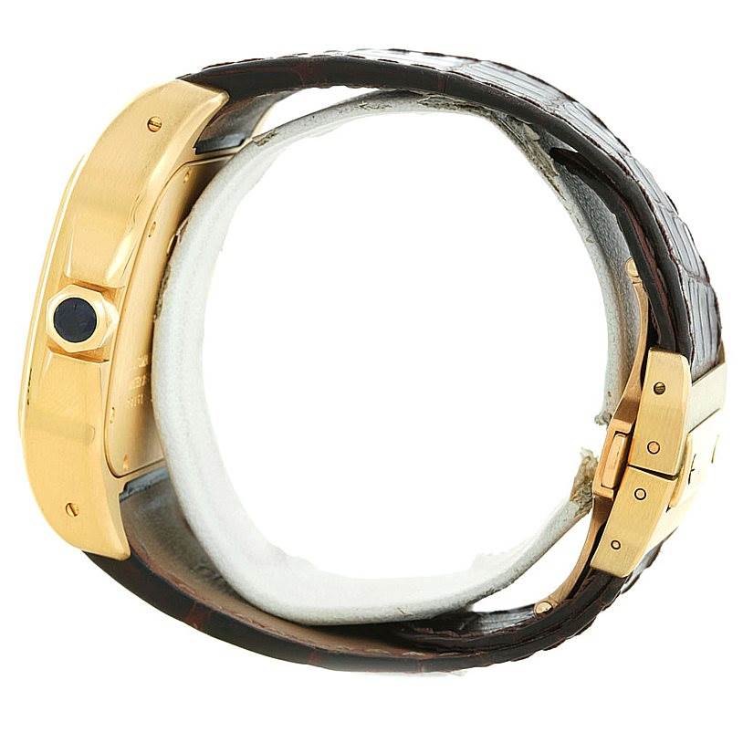 The image shows a Cartier Santos W20071Y1 Men's Yellow Gold Silver Dial W20071Y1 Men's Yellow Gold Silver Dial watch from a side angle, highlighting the gold case, crown, and leather strap with a clasp.