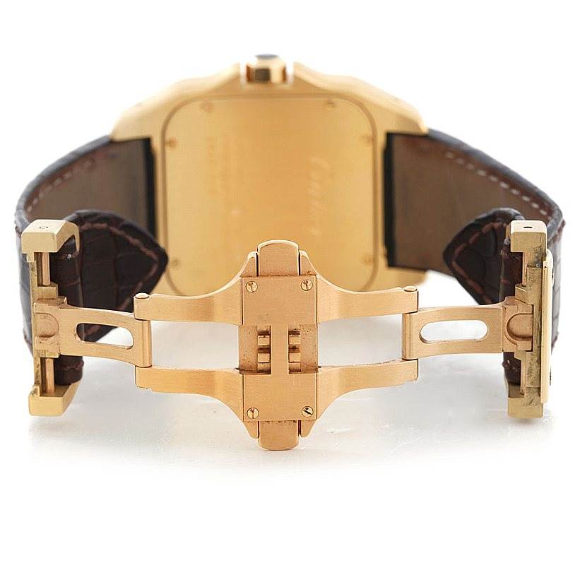 The image shows the back view of the Santos de Cartier watch, highlighting its gold clasp and brown leather strap.