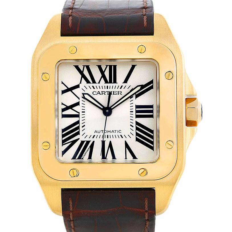 The image shows a front view of a Cartier Santos W20071Y1 Men's Yellow Gold Silver Dial W20071Y1 Men's Yellow Gold Silver Dial watch, highlighting its face, bezel, and part of the leather strap.