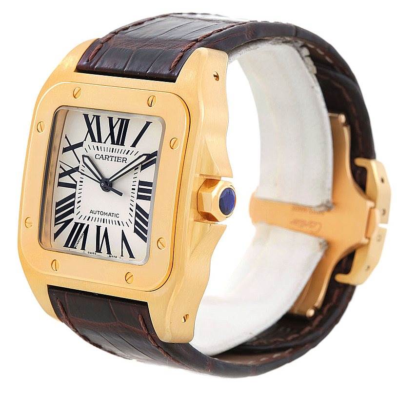 This Cartier Santos W20071Y1 Men's Yellow Gold Silver Dial W20071Y1 Men's Yellow Gold Silver Dial watch is shown from an angled side view, highlighting its gold case, white dial, and leather strap.