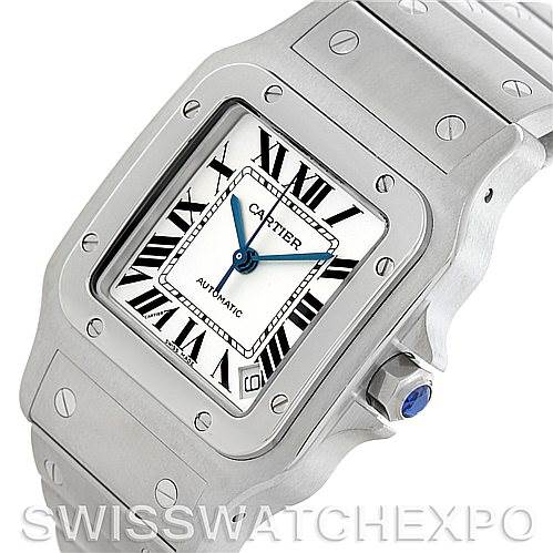 The image shows a close-up of the Cartier Santos W20098D6 Men
s Stainless Steel Silver Dial W20098D6 Men
s Stainless Steel Silver Dial watch face and part of the bracelet, highlighting the Roman numerals and blue crown.