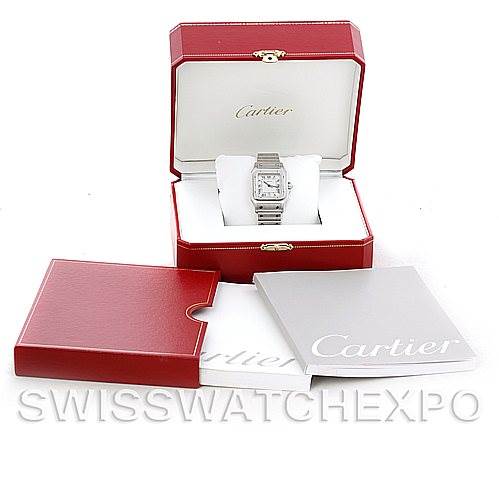 The image shows a front view of a Santos de Cartier watch in its original red box with additional packaging and a manual.