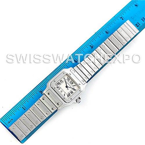 The image shows a top-down view of a Cartier Santos W20060D6 Men's Stainless Steel Silver Dial W20060D6 Men's Stainless Steel Silver Dial watch with a silver strap alongside a blue ruler for size reference.