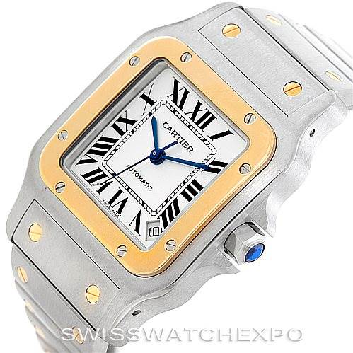 This image shows a Cartier Santos W20099C4 Men
s Stainless Steel Silver Dial W20099C4 Men
s Stainless Steel Silver Dial watch at an angled view highlighting its square face, gold bezel, screws, and crown with a blue gemstone.