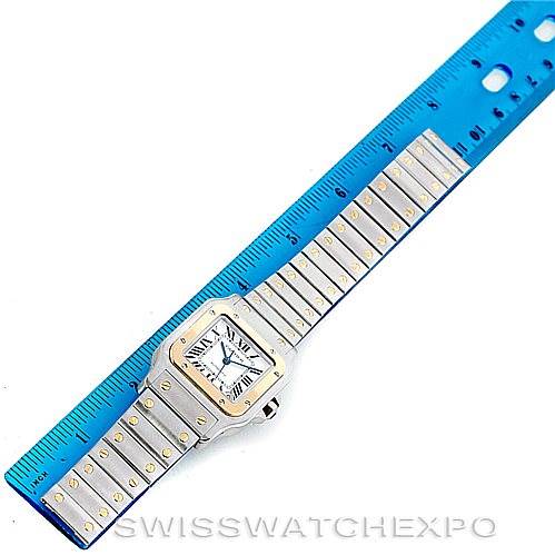 The image shows a top view of a Santos model watch by Cartier, with a ruler measuring its bracelet length.