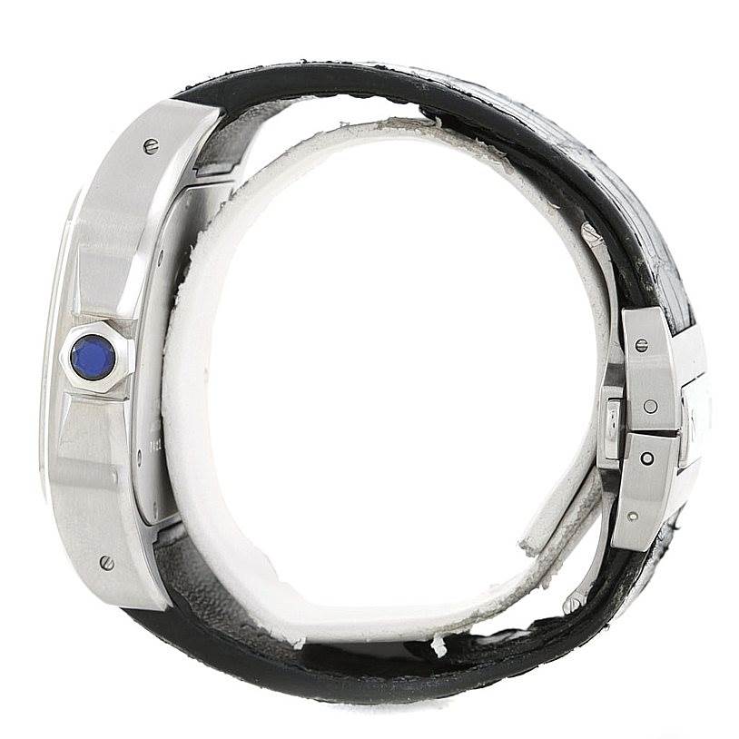 Side view of a Santos model by Cartier, showing the crown with a blue gem and part of the black leather strap.