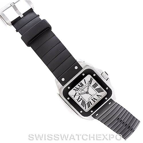 The Cartier Santos W20121U2 Men
s Stainless Steel Silver Dial W20121U2 Men
s Stainless Steel Silver Dial watch is shown from an overhead angle, displaying a black rubber strap and its square-shaped face with Roman numerals.
