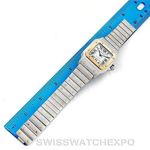 The image shows a top-down view of a Cartier Santos W20099C4 Men's Stainless Steel Silver Dial W20099C4 Men's Stainless Steel Silver Dial watch, including its face, strap, and a ruler for scale.