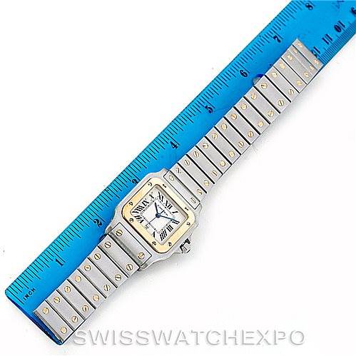 The image shows the Santos watch by Cartier laid flat, with the face and full bracelet visible, alongside a blue ruler.