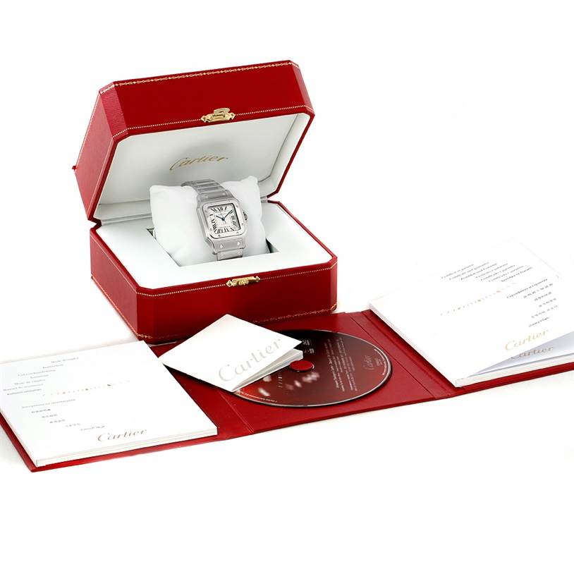 The image shows a Cartier Santos W20098D6 Men
s Stainless Steel Silver Dial W20098D6 Men
s Stainless Steel Silver Dial watch in its box, with accompanying booklets and a CD, all displayed at a slightly angled view.