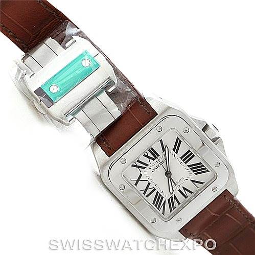 This image shows a Cartier Santos W20073X8 Men
s Stainless Steel Silver Dial W20073X8 Men
s Stainless Steel Silver Dial watch from a top-down angle, highlighting the watch face, case, and leather strap, with an extra clasp accessory.