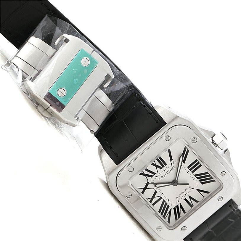 The image shows a Cartier Santos W20073X8 Men
s Stainless Steel Silver Dial W20073X8 Men
s Stainless Steel Silver Dial watch at an angle, highlighting its face, bezel, and part of the black leather strap.