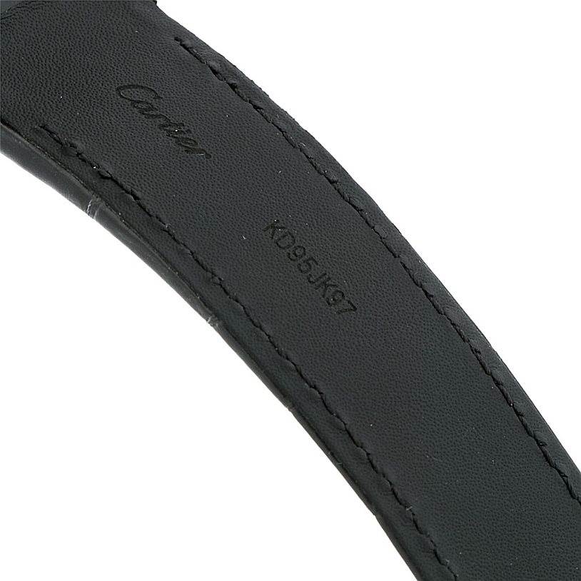 The image shows a close-up of the black strap of a Cartier Santos W20073X8 Men
s Stainless Steel Silver Dial W20073X8 Men
s Stainless Steel Silver Dial watch, featuring the Cartier logo and a serial number.