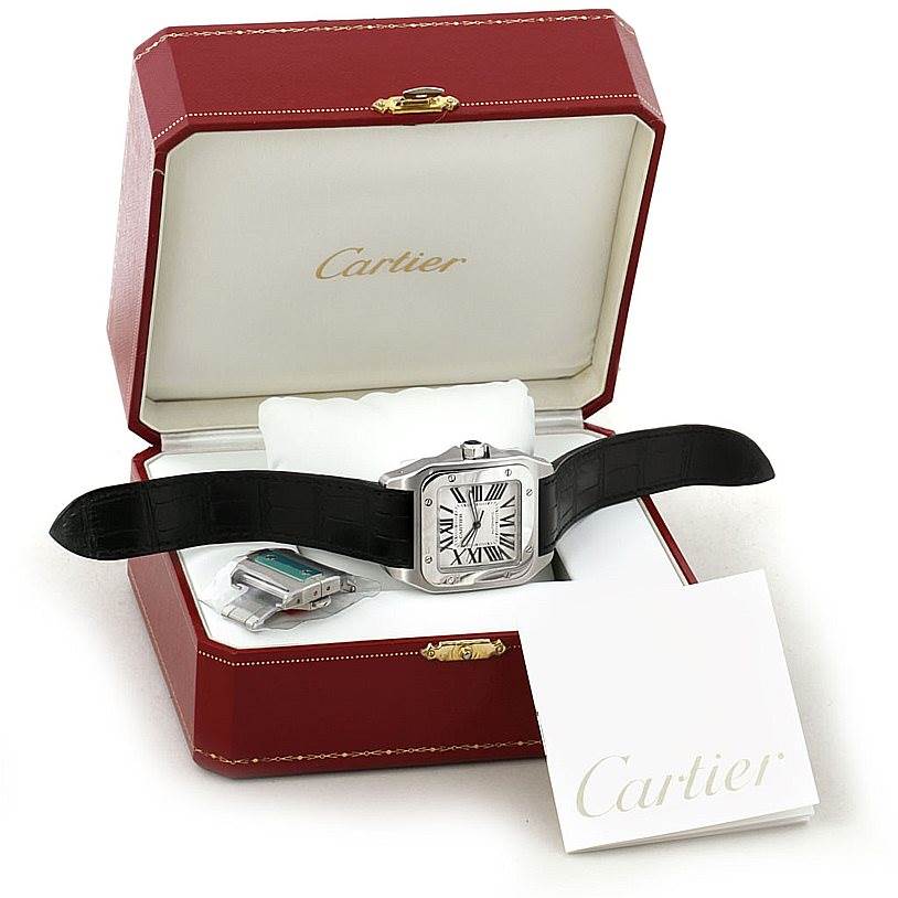 The image shows a Cartier Santos W20073X8 Men
s Stainless Steel Silver Dial W20073X8 Men
s Stainless Steel Silver Dial watch placed in an open red Cartier box, accompanied by accessories and documentation.