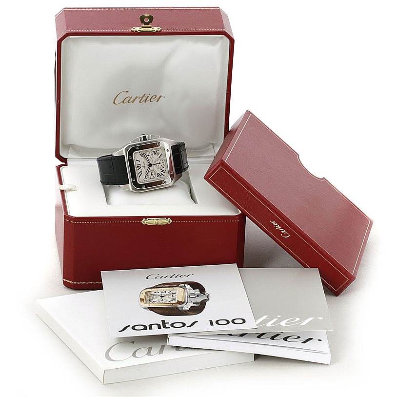 The image shows a Cartier Santos W20090X8 Men
s Stainless Steel Silver Dial W20090X8 Men
s Stainless Steel Silver Dial watch in a red display box, with an additional box and booklets surrounding it.