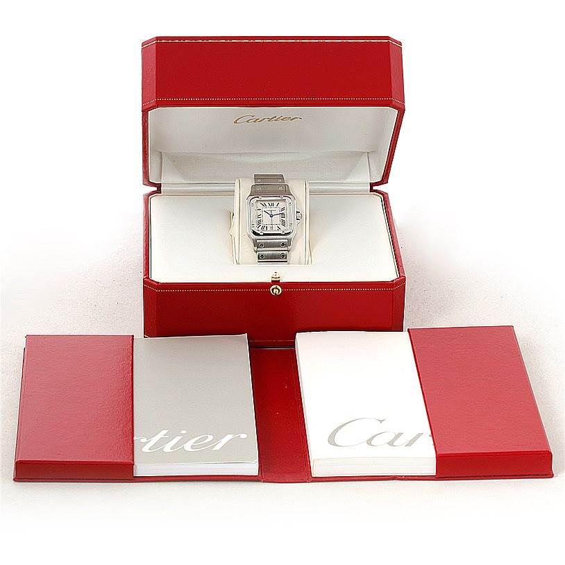 The image shows a Cartier Santos W20060D6 Men's Stainless Steel Silver Dial W20060D6 Men's Stainless Steel Silver Dial watch from the front, placed in an open red box with accompanying manuals in front.