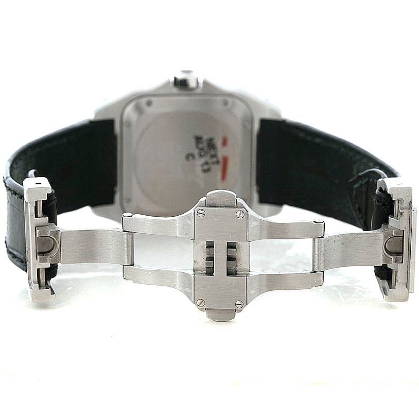 The image shows the back of the Cartier Santos W20106X8 Men
s Stainless Steel Silver Dial W20106X8 Men
s Stainless Steel Silver Dial watch with the focus on its open clasp and leather strap.