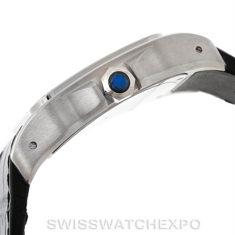 This image shows a side view of a Cartier Santos W20073X8 Men
s Stainless Steel Silver Dial W20073X8 Men
s Stainless Steel Silver Dial model watch featuring its crown with a blue sapphire cabochon.