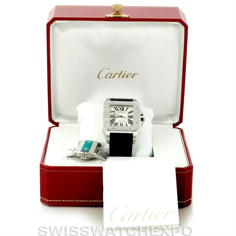 The image shows the Cartier Santos W20073X8 Men
s Stainless Steel Silver Dial W20073X8 Men
s Stainless Steel Silver Dial watch in an open Cartier box with an additional watch strap or clasp accessory.