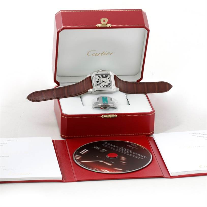 The Cartier Santos W20073X8 Men
s Stainless Steel Silver Dial W20073X8 Men
s Stainless Steel Silver Dial watch is displayed in an open box with a strap and is accompanied by a CD and documents.