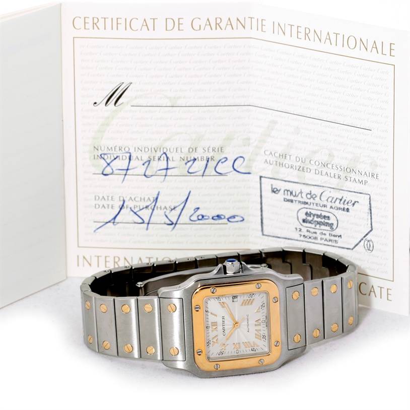 The image shows a Santos model by Cartier laying flat with its certificate of guarantee in the background.