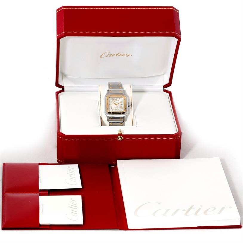 The Santos model by Cartier is displayed from the front, set in an open box with documentation and packaging shown.