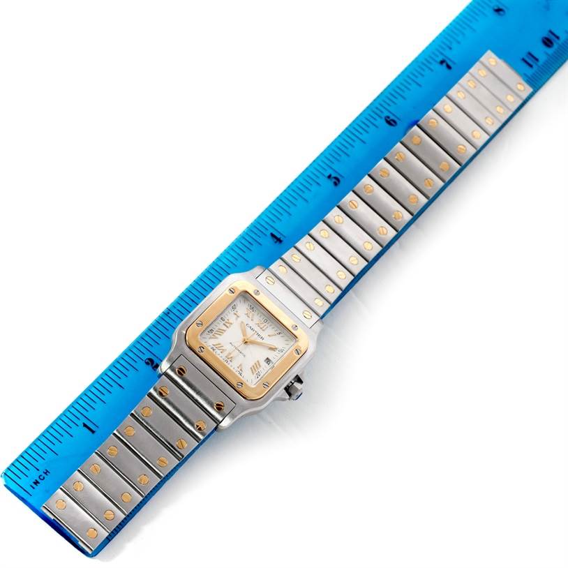 This image shows the front view of a Cartier Santos W20058C4 Men's Stainless Steel Silver Dial W20058C4 Men's Stainless Steel Silver Dial watch, with the face and full bracelet visible alongside a blue measuring ruler.