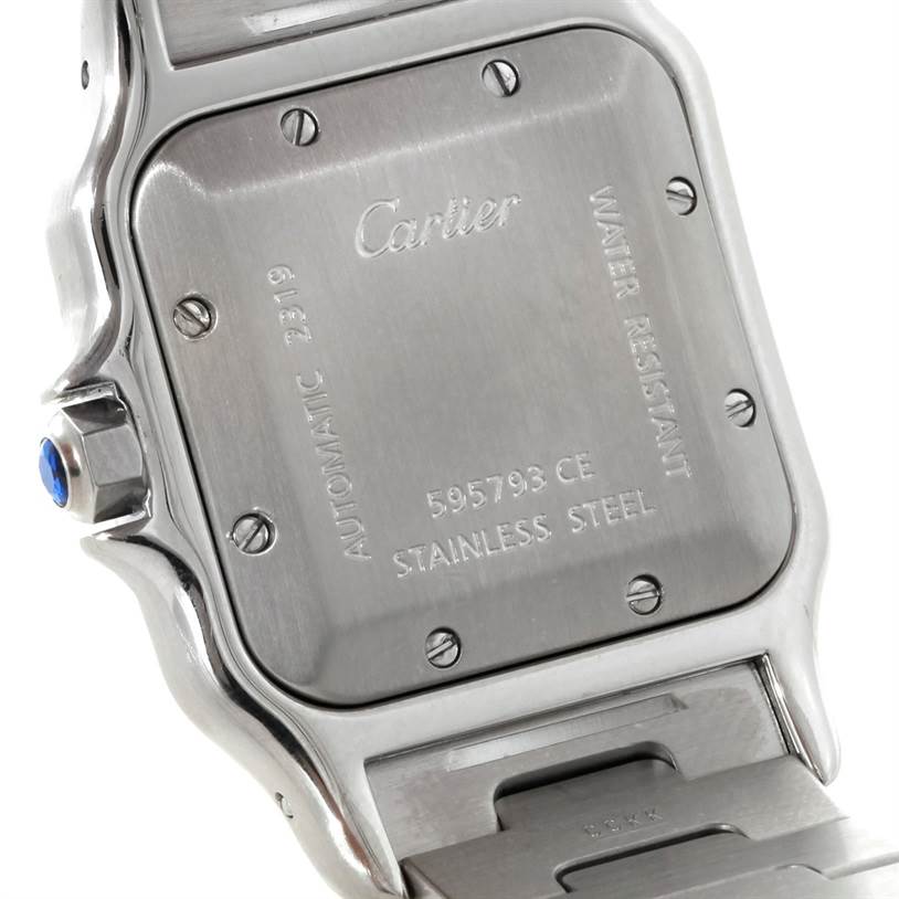 The image shows the back case, screws, crown, and part of the bracelet of a Santos model by Cartier.