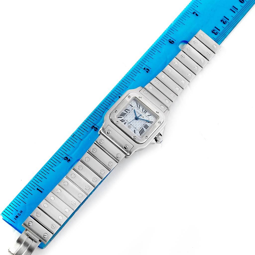 The photo shows a Santos model watch by Cartier, including its face and bracelet, measured against a blue ruler.
