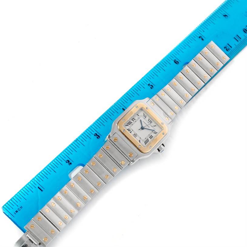 The image shows a Cartier Santos W20011C4 Stainless Steel Silver Dial W20011C4 Stainless Steel Silver Dial watch laid flat next to a ruler, displaying both the face and the full metal bracelet.