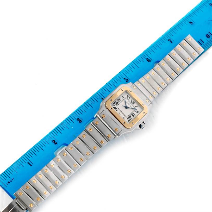 The Cartier Santos W20011C4 Stainless Steel Silver Dial W20011C4 Stainless Steel Silver Dial watch is shown face-up with its band and case, measured against a blue ruler.