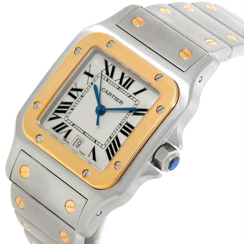The Cartier Santos W20011C4 Stainless Steel Silver Dial W20011C4 Stainless Steel Silver Dial watch is pictured at an angle showing the face, gold bezel, crown, and portions of the metal bracelet.